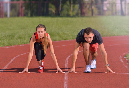 Young sport couple in starting position prepared to competeの写真素材