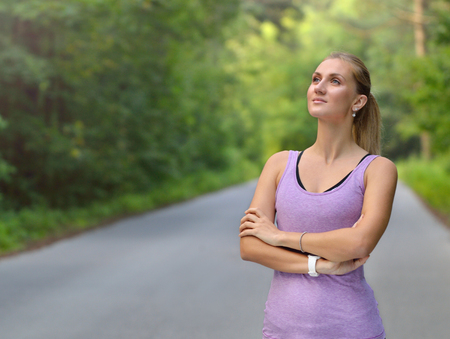 Young fitness woman stay in the park with crossed ones armsの写真素材