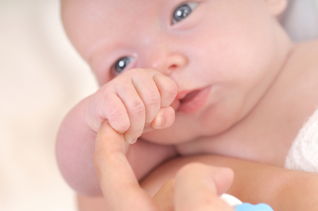 Newborn baby hand holding finger of motherの写真素材