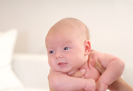 Adorable beautiful newborn baby cradled in its mothers handsの写真素材