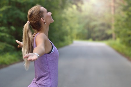 Joyful woman breathing fresh air outdoorsの写真素材