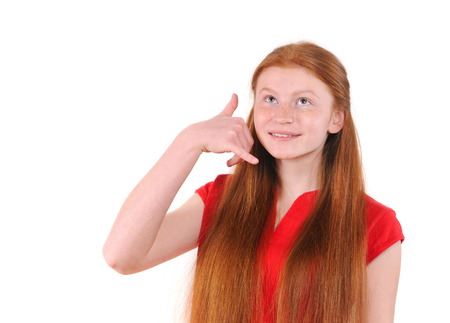 Red hair teenager girl in a red shirt showing a call me signの写真素材