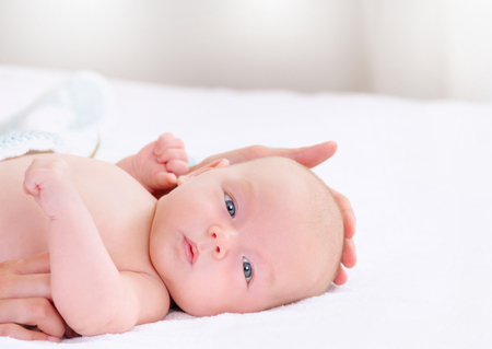 Newborn baby lying on caring mothers hand. Concept of baby care.の写真素材