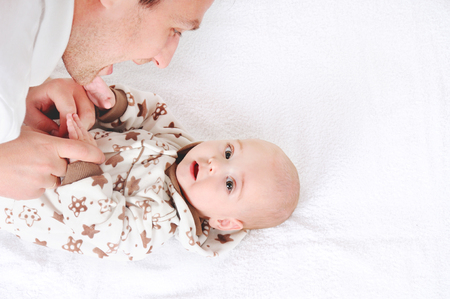 Portrait of happy young smiling father playing with baby over white background. Happy fatherhood conceptの写真素材