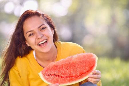 Happy young woman with watermelon in the park. Youth lifestyle. Happiness, joy, holiday, beach, summer conceptの写真素材