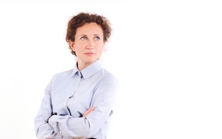 Beautiful mature business woman isolated over white background. Smiling curly hair business woman with folded hands against white backgroundの写真素材