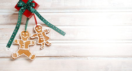Flat lay xmas gingerbread man on wooden boards. Christmas homemade gingerbread cookies over wooden backgroundの写真素材