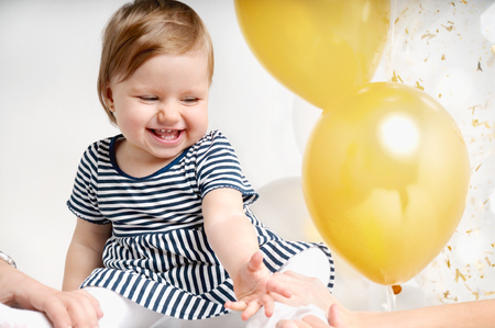 Pretty little girl playing with colorful balloons. Cute infant with group of ballsの写真素材