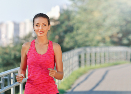 Fitness woman running. Woman jogging on urban road. Fitness girl training outdoorの写真素材
