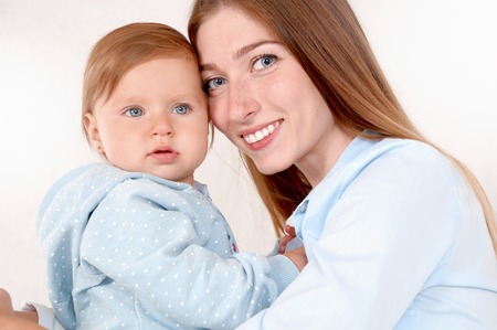Portrait of beautiful mom and her baby in bedroom. Happy childhood and maternity concept.の写真素材