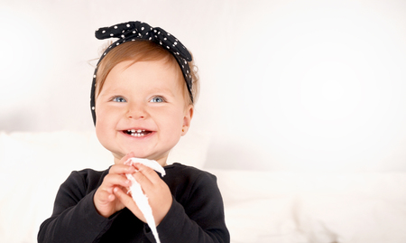Cute baby girl dressed in a black dress on white light background. Happy childhood conceptの写真素材