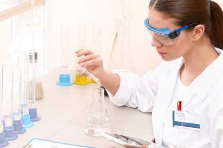 Top view of smiling young woman scientist while working in the laboratory. Healthcare and biotechnology concept.の写真素材
