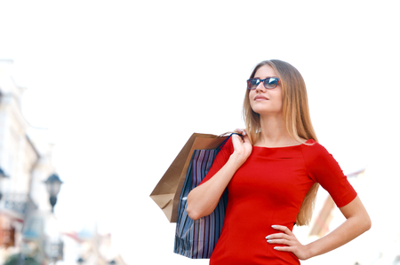 Portrait young charming long-haired woman holding shopping bags. Shopping sales and perfect mood. Design model fashion glasses.の写真素材