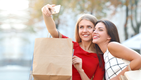 Two beautiful young women taking a selfie with their cell phone. Lifestyle, friendship and people conceptの写真素材