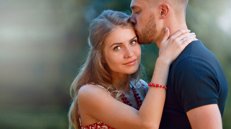 Portrait of young attractive woman whith her man relaxing in green park. Love, friendship and family conceptの写真素材