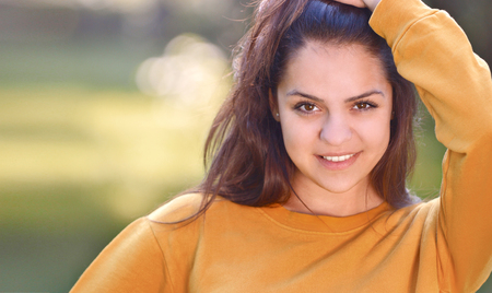 Young pretty girl in autumn or summer park. Close up portraitの写真素材