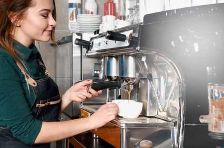woman making coffee by coffee machine in coffee shop cafe. Food and drink industry conceptの写真素材