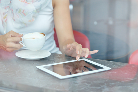 Woman use a touch pad screen while standing in modern cafe. Communication conceptの写真素材