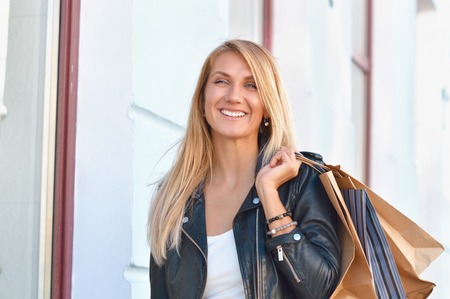 Portrait young charming long-haired woman holding shopping bags. Shopping sales and perfect moodの写真素材