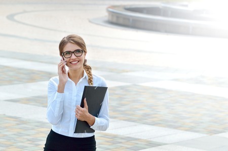 Business woman office worker talking on smartphone smiling happy. Business people - woman on smart phoneの写真素材