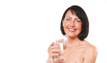 Mature woman hold glass of water. Beauty and care conceptの写真素材