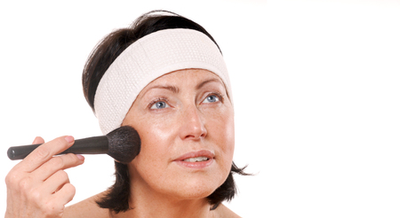 Mature woman applying makeup. Beauty and care conceptの写真素材