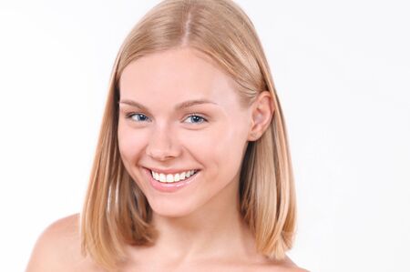 Pretty smiling joyfully female with blonde hair. Studio shot of good-looking beautiful woman isolated against blank studio wallの写真素材
