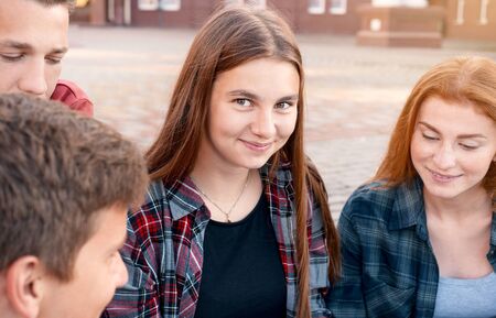 Happy teenager girl with her friends studying near university outdoors. Education conceptの写真素材