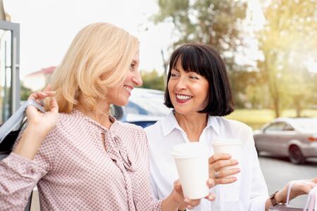 Two mature women having fun while doing shopping and drinking coffee. Pastime concept of mature peopleの写真素材