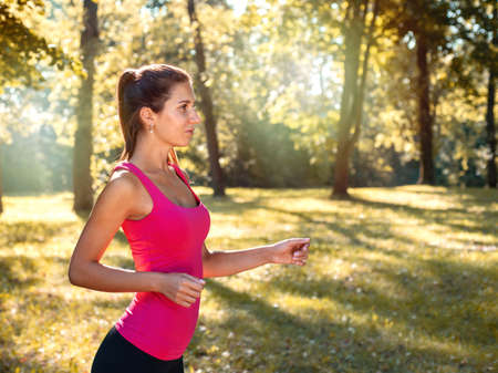 Portrait of young sporty woman running in the park outdoor. Healthy lifestyle conceptの写真素材