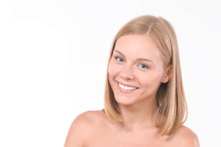 Pretty smiling joyfully female with blonde hair. Studio shot of good-looking beautiful woman isolated against blank studio wallの写真素材