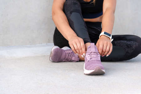 Fitness sporty woman is preparing for running. Close up shoot of sporty sneakers.. Healthy lifestyle concept.の写真素材