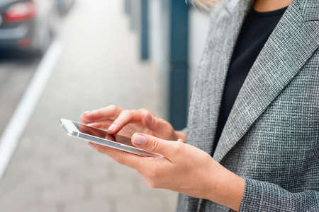 Closeup shoot of woman's hands with the phone at the business center outdoors. Working lifestyle conceptの写真素材