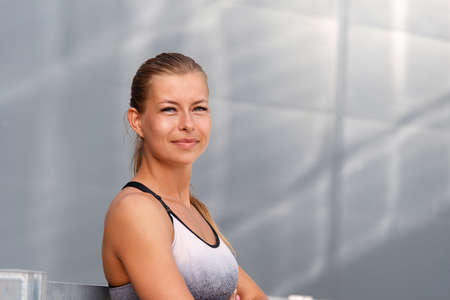 Portrait of healthy fitness sporty smiling woman early in the morning city at sunrise.Healthy lifestyle concept.の写真素材