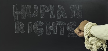 written the word human rights with knotted hand on the blackboardの写真素材