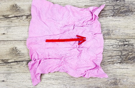 a red wooden arrow on a pink ragの写真素材