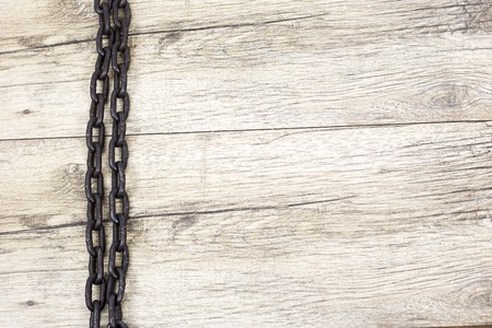 old rusty chain lays on wooden backgroundの写真素材