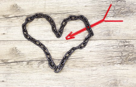 Chain heart shape with red wooden arrowの写真素材