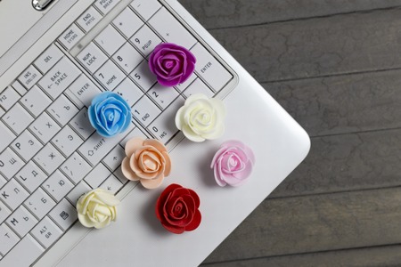 top view of colourful roses and white laptopの写真素材