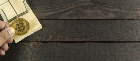 wooden mouse trap and man holds bitcoinの写真素材