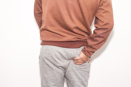 man having ache hemmoroid on white background
