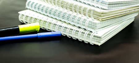 notebooks and two markers on black backgroundの写真素材