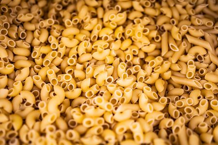Texture of uncooked italian pasta. Background of many pasta
