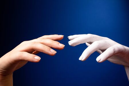 Hand gesture. Human gesture. Two hands are drawn to each other on a blue background. Hands on a background of blue wallの写真素材