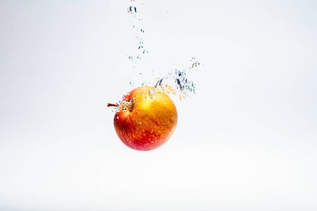red ripe apple thrown into the waterの写真素材