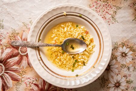a plate with leftover soup with noodles. Unfinished soup on the old. View from aboveの写真素材