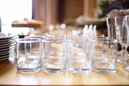 transparent clean empty glass glasses stand on a table in rows.の写真素材