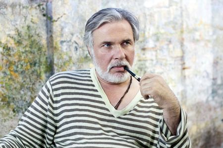 Portrait of a mature man smoking tobacco pipe