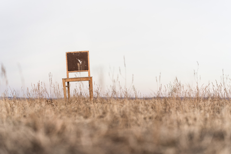 Lonely old wooden chair in the middle of a fieldの写真素材