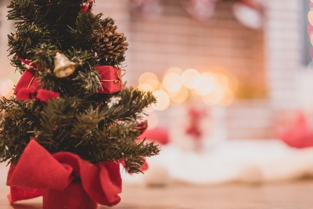 Decorated christmas tree on fireplace background at homeの写真素材